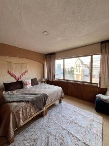a bedroom with a bed and a large window at Casa Bohemia in Ciudad Guzmán