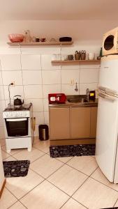 a kitchen with a white refrigerator and a stove at Apartamento perto do HCAA - com Garagem in Santa Maria
