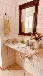 a bathroom with a sink and a mirror at Apartamento perto do HCAA - com Garagem in Santa Maria +9 photos