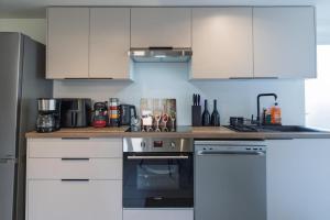 a kitchen with white cabinets and a stove top oven at Le Gerbolle in Reventin-Vaugris
