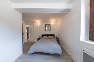 a bedroom with a bed in a white room at Le Gerbolle in Reventin-Vaugris