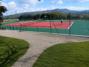 two people playing tennis on a tennis court at Riparossa charme apt - tennis court and pool in Chianni