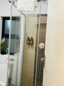 a bathroom with a shower with a glass door at The Kgale Luxe in Gaborone +20 photos