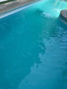 a swimming pool with blue water in it at GrandMaré Hotel in Peruíbe