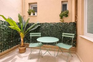 a table and chairs on a patio with a wall at Wake in the Lake III in Agios Nikolaos