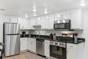 a kitchen with white cabinets and a stainless steel refrigerator at Serene Creek Condo Pool & Gym in Branson