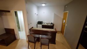 a small kitchen with a table and chairs in a room at Prinz Apart Hotel in Joinville