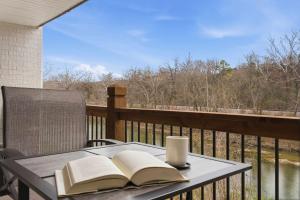 a table with two books and a cup on a balcony at Serene Creek Condo Pool & Gym in Branson