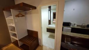 a small bathroom with a sink and a mirror at Prinz Apart Hotel in Joinville