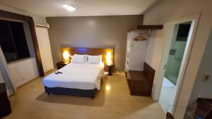 a hotel room with a bed and a bathroom at Prinz Apart Hotel in Joinville +49 photos