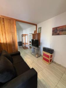 a living room with a couch and a television at Amanecer Rio Limay in Plottier
