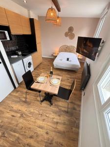 a small kitchen and dining room with a table and chairs at 2 Neufchâtel studio agréable et cosy tout équipé in Reims