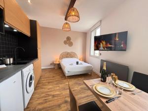 a kitchen and a living room with a dining table and a living room at 2 Neufchâtel studio agréable et cosy tout équipé in Reims