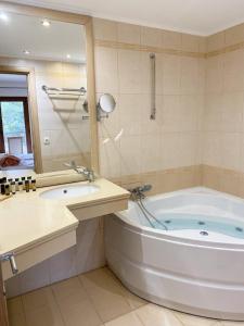 a bathroom with a tub and a sink and a mirror at Cave Luxury Villas Skiathos in Troulos +24 photos