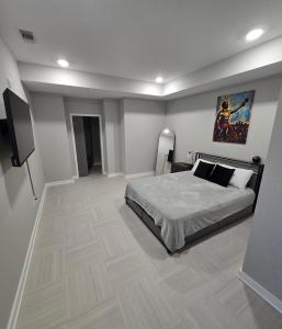 a bedroom with a bed and a flat screen tv at Immaculate Vibes Sunset View Condo in Birmingham