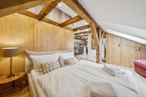 a large bed in a room with wooden walls at MEL&BENS Altstadt Suites mit Parkoption in Celle