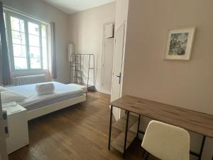 a room with a bed and a table and a window at Le Louis d'Or in Beaumont-sur-Sarthe