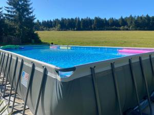 a swimming pool with a fence next to a field at Erzhof Nassau- Gästezimmer an der Loipe in Bienenmühle