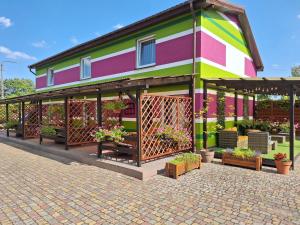 a colorful building with potted plants on it at Pokoje Podzamcze in Stare Drawsko +74 photos