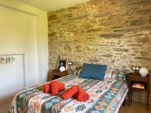 a bedroom with a bed with red pillows on it at Casa Lambre in Paderne