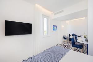 a white room with a bed and a table and chairs at Palazzo Sant'Elena in Anacapri