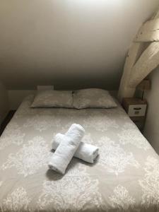 ein Bett mit zwei zusammengerollten Handtüchern darauf in der Unterkunft Orléans Appartement 2 chambres avec Parking in Orléans