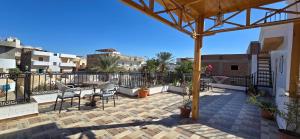 a patio with a table and chairs on a balcony at Villa golden life apartments, new property with pool access in Luxor