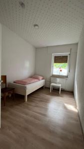 a small bedroom with a bed and a window at Pension Highway 3 - Preußisch Oldendorf Goethestraße 6 in Preußisch Oldendorf +2 photos