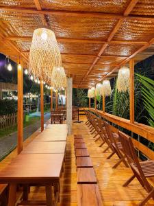 a long wooden table with chairs and a chandelier at Biển Tôm ốc Homestay Bến Tre - Hồ Bơi & BBQ Garden in Ấp Sơn Thuận (2)