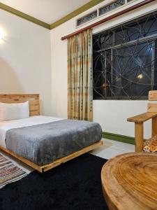 a bedroom with a bed and a table at Aivilo Home in Entebbe