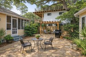 a patio with chairs and a table in front of a house at Cabin in Tybee Island, Georgia in Tybee Island