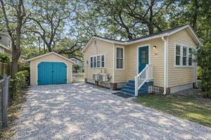 a small yellow house with a blue garage at Cabin in Tybee Island, Georgia in Tybee Island +44 photos