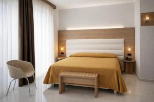 a bedroom with a bed and a chair at Hotiday Corato in Corato