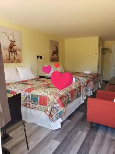 a hotel room with two beds with hearts on them at Motel Domaine Expédition in Labelle