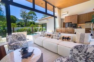 a living room with a couch and chairs and a table at Villa Babylon Chaweng in Koh Samui