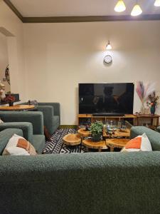 a living room with couches and a flat screen tv at Aivilo Home in Entebbe