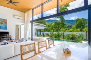an open living room with a table and chairs at Villa Babylon Chaweng in Koh Samui