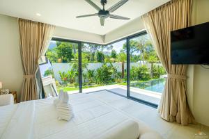 a bedroom with a large bed and a large window at Villa Babylon Chaweng in Koh Samui