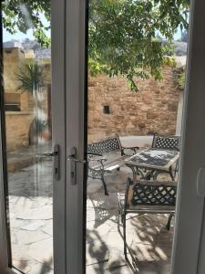 an open door to a patio with a table and chairs at Mulberry Tree Cottage Episkopi Paphos in Episkopi Pafou