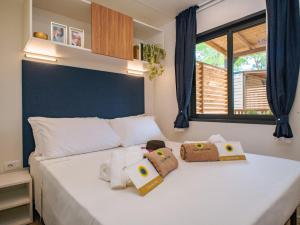a bedroom with a white bed with pillows and a window at Club del Sole Due Laghi Levico Family Collection in Levico Terme +70 photos