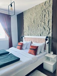 a bedroom with two beds with pillows and a wall at Apartman Viktorija in Žabljak