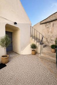 a building with stairs and a door with two potted plants at L'échappée belle, en Champagne in Dormans
