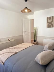 a bedroom with a bed with a blue blanket at L'échappée belle, en Champagne in Dormans