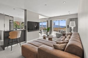 a living room with a large couch and a television at Riviera Beach Hotel in Mandelieu-La Napoule
