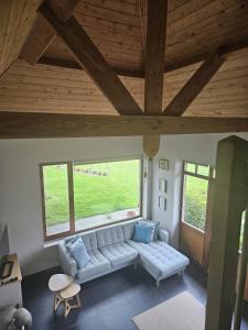 a living room with a couch and two windows at B&B Chocla-dort in Koekelare