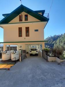 a house with a car parked in the driveway at Aagaman Woods in Shimla