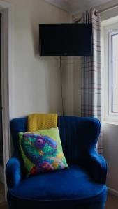 a blue couch with a colorful pillow on it at Yaxham Mill in East Dereham