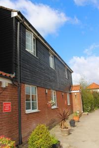 a red brick house with a black roof at Yaxham Mill in East Dereham
