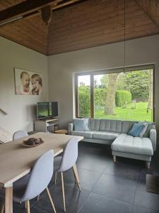a living room with a couch and a table at B&B Chocla-dort in Koekelare