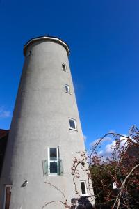 a tall lighthouse with a blue sky in the background at Yaxham Mill in East Dereham +10 photos